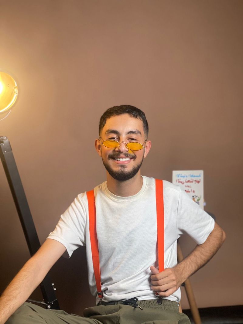 Walid Idriss, smiling, in a white T-shirt and red braces